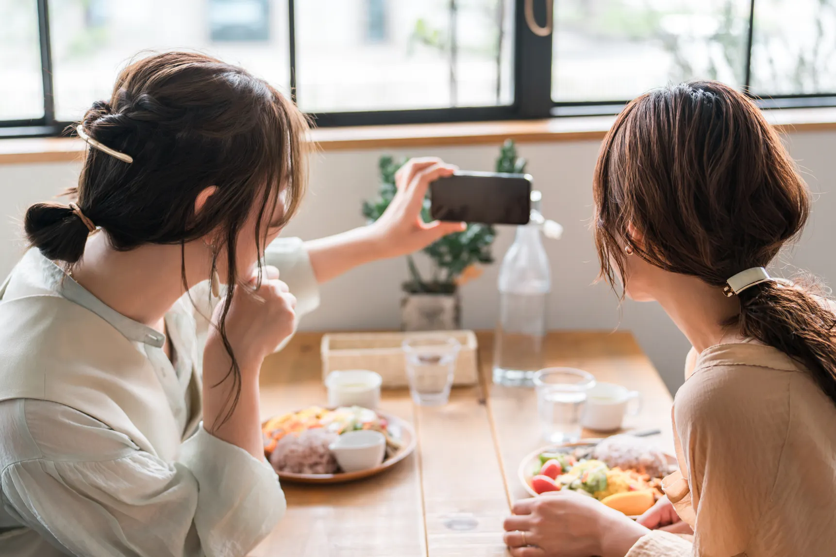 スマートフォンで撮影する2人の女性