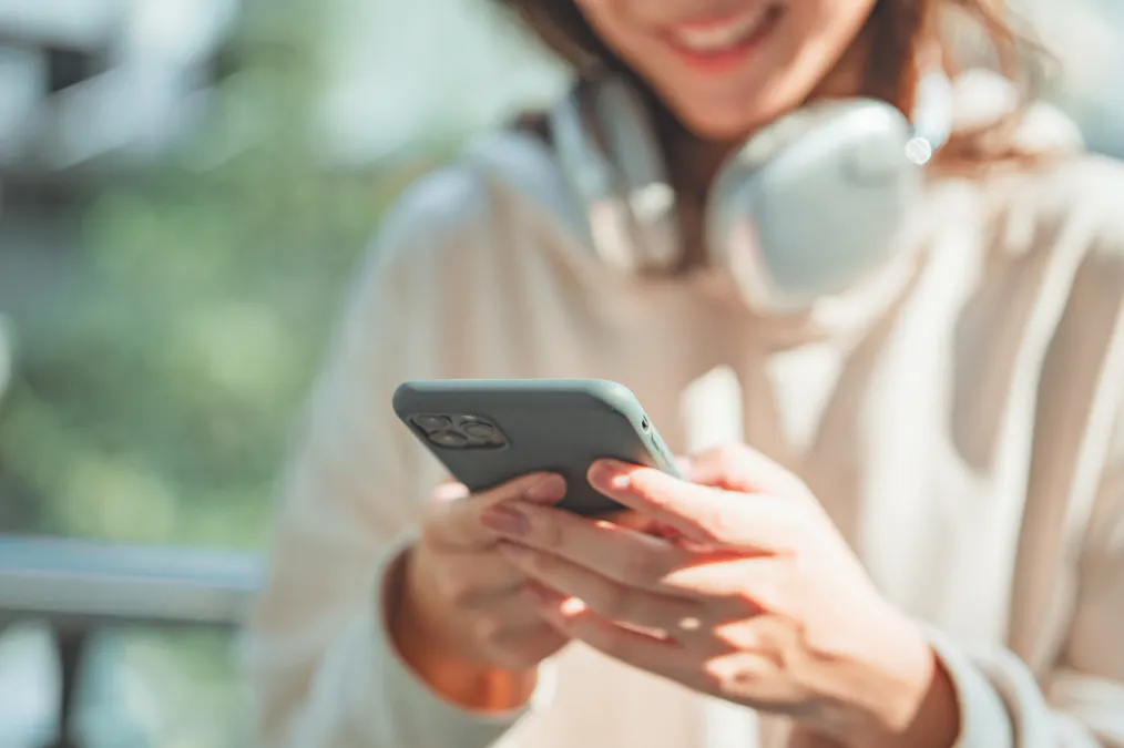 スマートフォンを手に微笑む女性